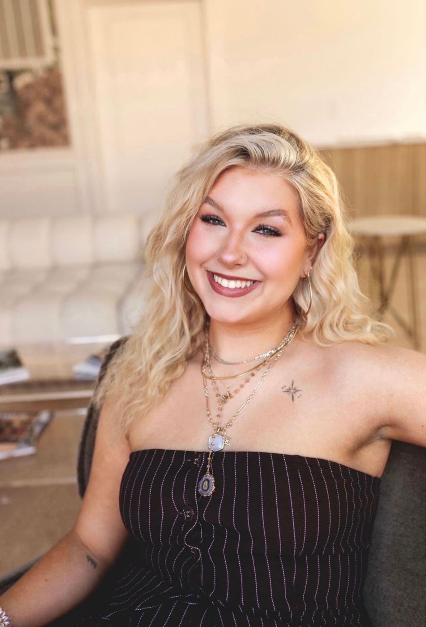 Marleigh Clemmons, smiling, with tousled blonde hair and layered necklaces.